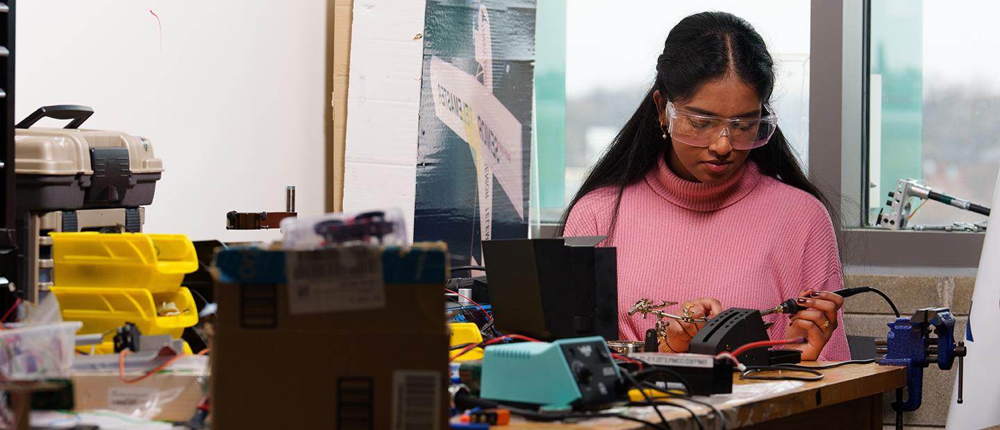 A young woman working on electrical equipment